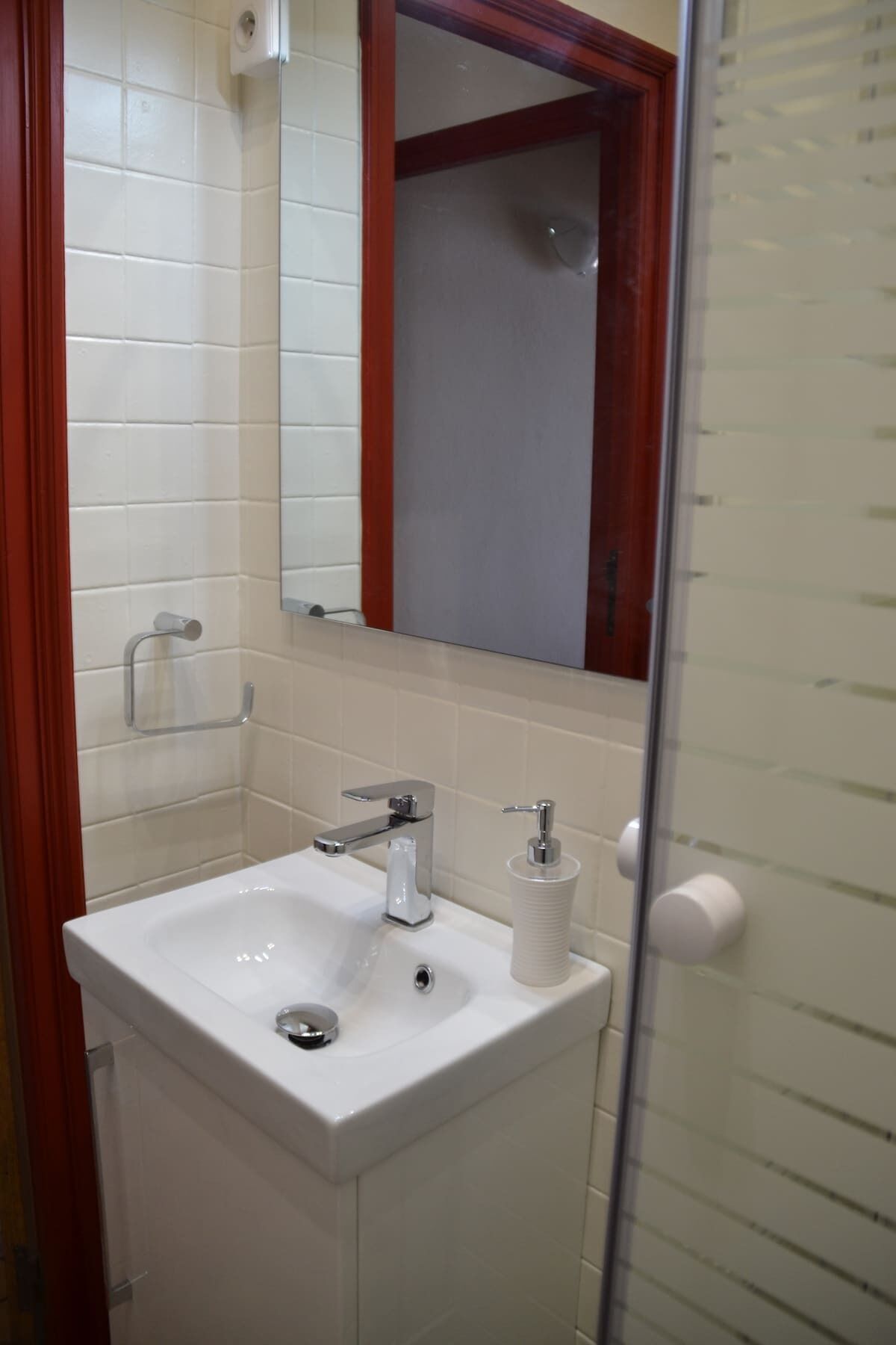 A bathroom with a white sink, a mirror, and a toilet.