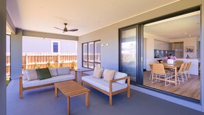 Una sala de estar moderna con un sofá, una mesa de centro y un ventilador de techo.