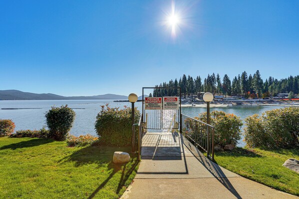 A private property sign at the entrance of a waterfront property with a clear view of the lake and mountains in the background.