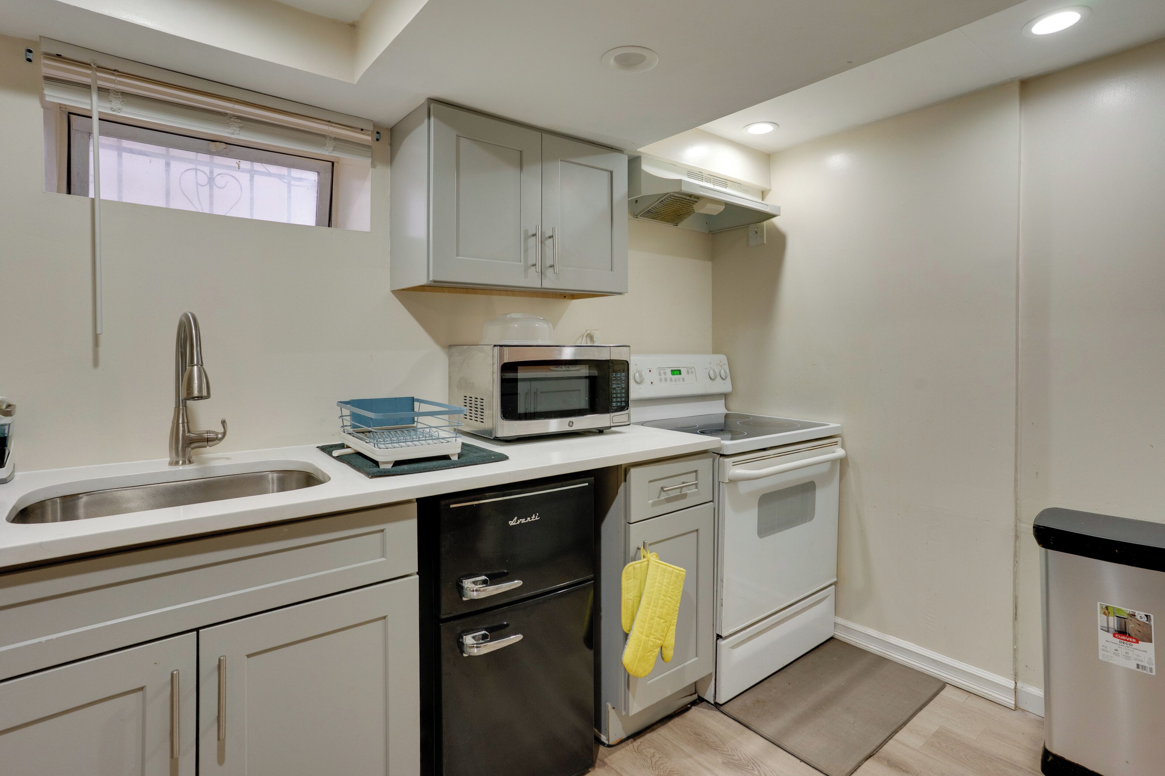 A compact kitchen with a microwave, oven, and dishwasher.