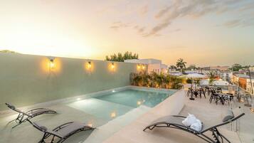 Una piscina al aire libre, sillones reclinables de piscina