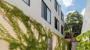 Un bâtiment moderne à la façade blanche, doté de grandes fenêtres et d’une galerie couverte.