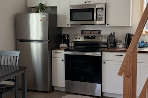 Une cuisine équipée d’un réfrigérateur en acier inoxydable, d’un four à micro-ondes, d’une cuisinière et d’une pancarte au-dessus de la cuisinière sur laquelle on peut lire : « Saumon rouge ».