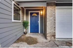 A house with a blue door, a small potted plant, and a doormat with "WELCOME" written on it. - Fabulous 3-bedroom house with AC in vibrant Austin (Austin)