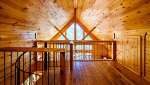 A wooden cabin with a high ceiling and a central skylight. - Bucky’s Blind · Cozy Forest Escape: Hot Tub, Playground, Fire Pit (Broken Bow)