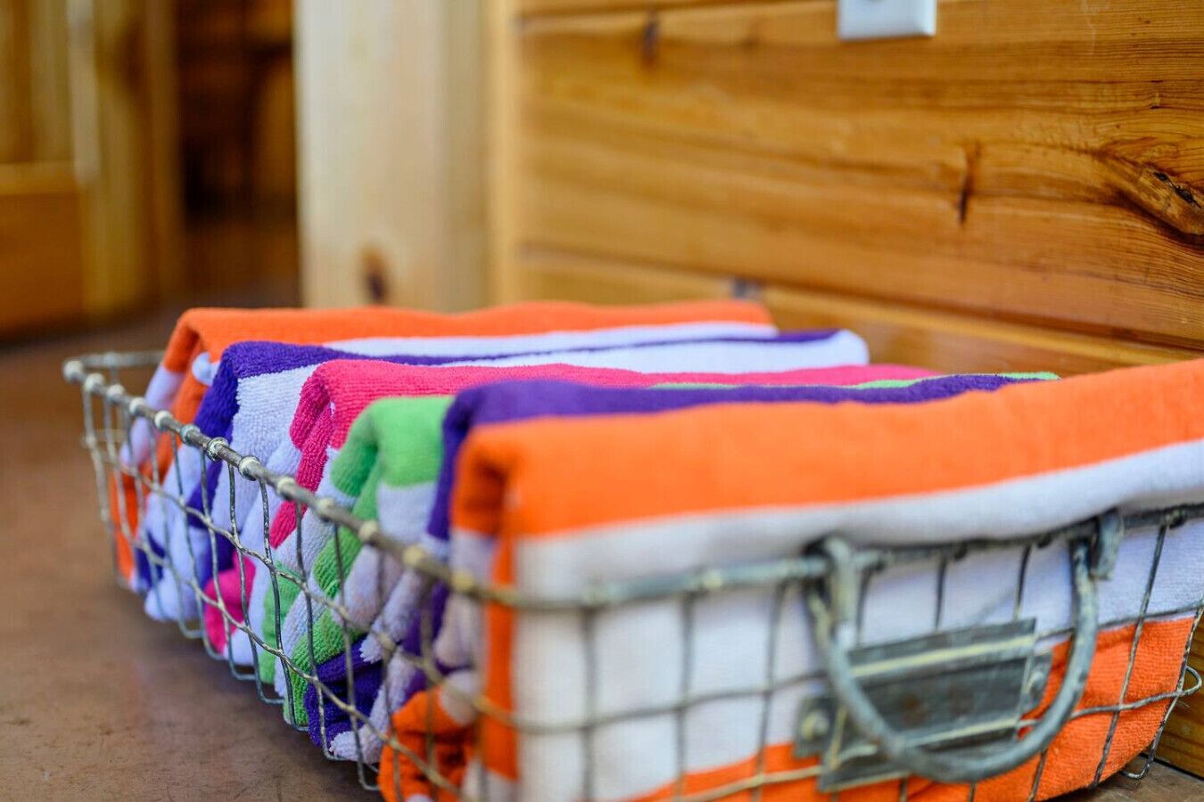 A metal basket filled with colorful towels.