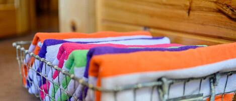 A metal basket filled with colorful towels.