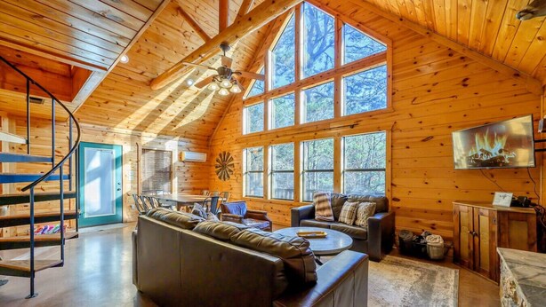 A spacious cabin interior with a large wooden ceiling, a cozy seating area, and a dining space. - Bucky’s Blind · Cozy Forest Escape: Hot Tub, Playground, Fire Pit (Broken Bow)