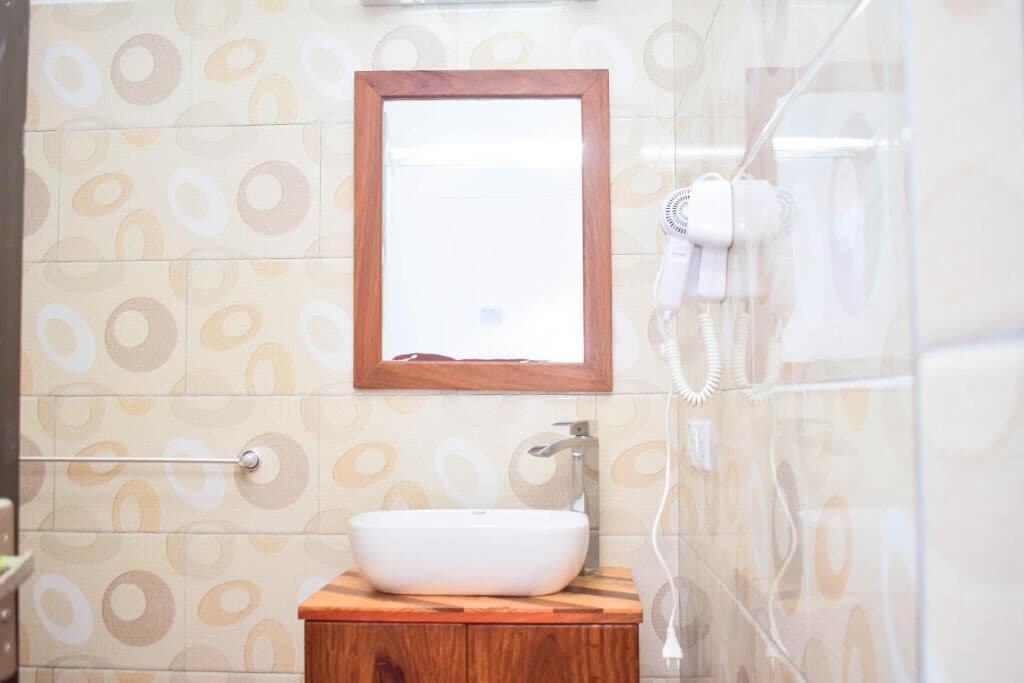 Une salle de bain avec un meuble-lavabo en bois, un lavabo blanc et un miroir au-dessus.