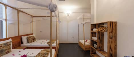 A room with two beds, a wardrobe, and a small table with cups and saucers.