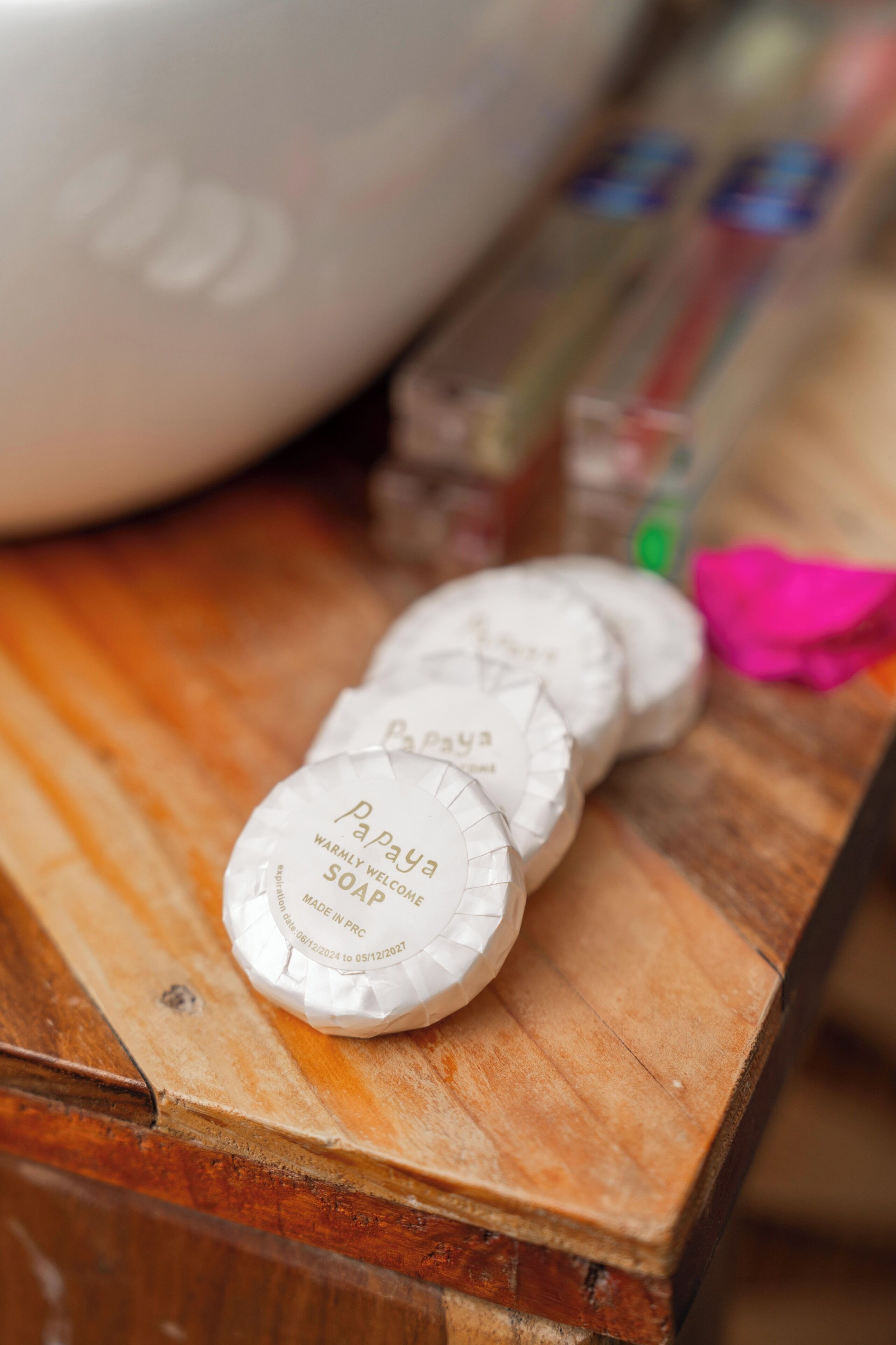 Three soap bars on a wooden surface.