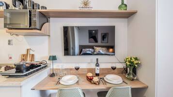 Cozinha moderna com micro-ondas, fogão e mesa de jantar posta para dois.