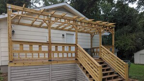 A wooden deck with a pergola and stairs leading to a house. - Charming 3-bedroom cottage by downtown Atlanta (Atlanta)