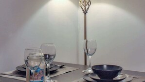 Een eettafel gedekt met een fles melk, twee wijnglazen, een waterglas en een schaal.