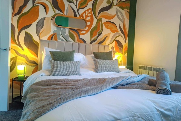 Comfortable king bedroom with stylish feature wall, quality bedding and soft lighting for a great night’s sleep after work or travel.