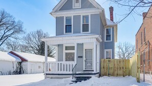 A two-story house with a front porch, a chimney, and a wooden fence. - Walk to Trolley District: Olde Towne East Retreat (Columbus)