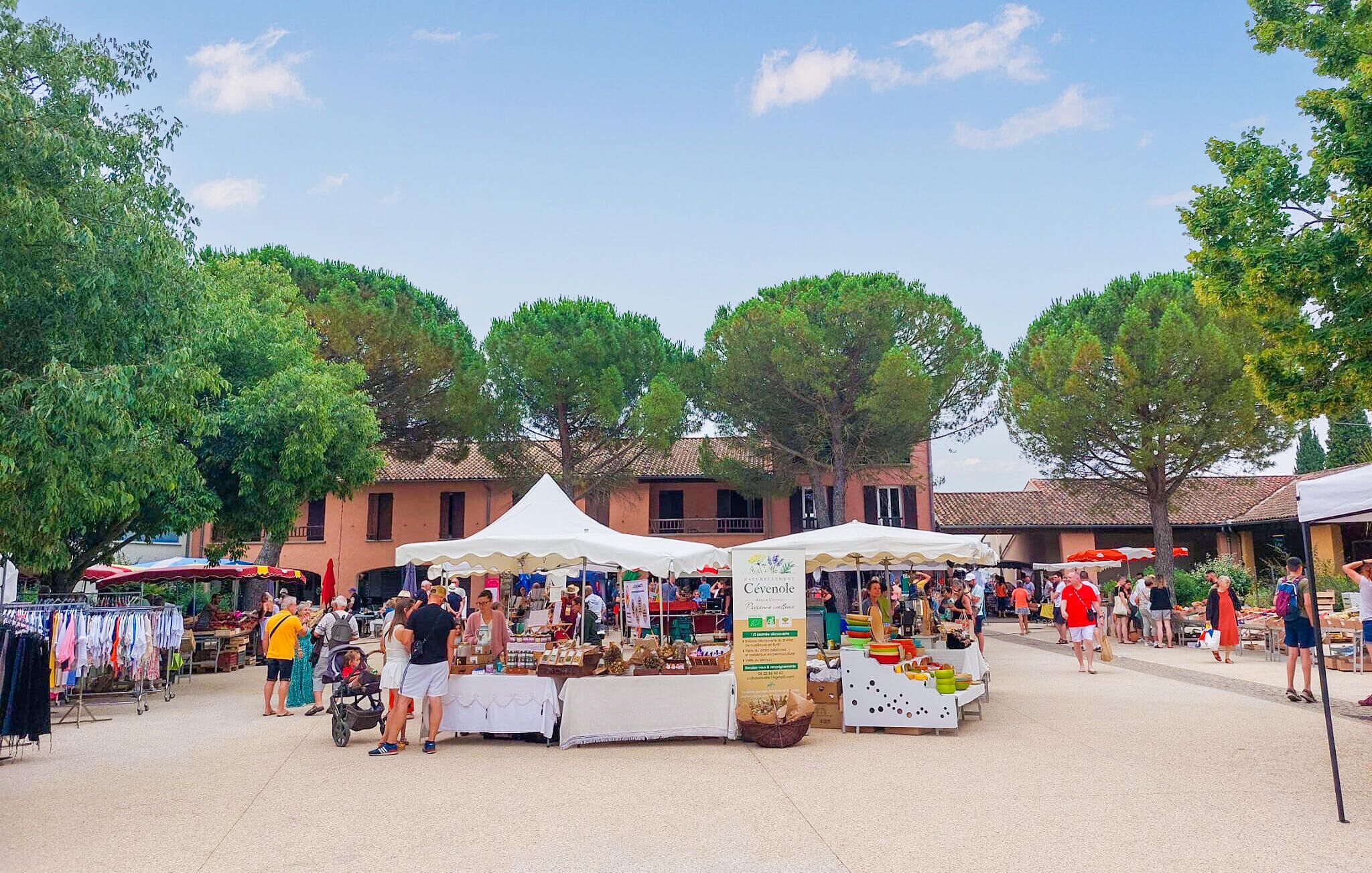 Un mercat a l'aire lliure amb diferents parades i gent de compres.