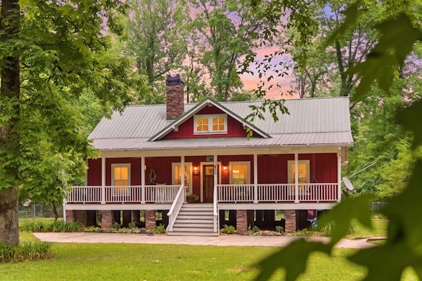 A two-story house with a front porch, stone chimney, and a number '800' on the door.