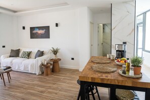 Ein modernes Wohnzimmer mit Sofa, Couchtisch und Esstisch.