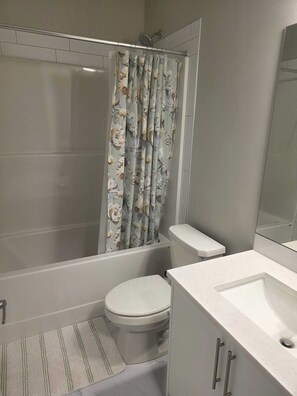 A bathroom with a shower, toilet, and sink. - Cheerful Home away from Home (Calgary)