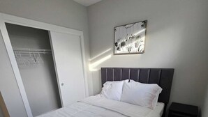 Una camera da letto con un letto, un armadio e un comodino.