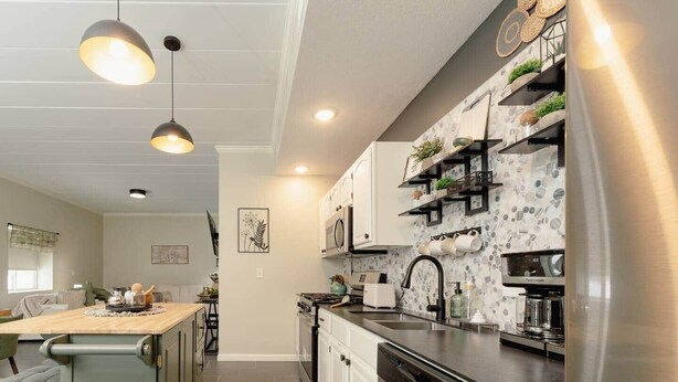 A modern kitchen with a central island, stainless steel appliances, and pendant lighting. - Luxurious One-Bedroom Gem Near Conneaut Lake (Conneaut Lakeshore)