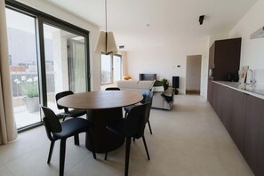 Una cucina moderna con zona pranzo, ampie finestre e vista sulla città.