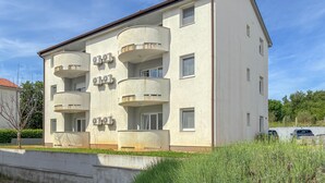 Ein mehrgeschossiges Gebäude mit Balkonen, Fenstern und Klimaanlagen.