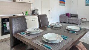 Ein moderner Essbereich mit einem dunklen Holztisch, gedeckt für vier Personen, umgeben von Ledersesseln.