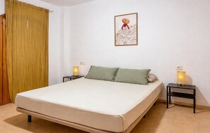 A bedroom with a bed, two bedside tables, a wall-mounted lamp, and a curtain. - 1 bedroom awesome apartment in Denia (Denia)