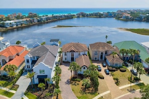 A residential area with houses along a waterfront, featuring a central building with a prominent entrance and solar panels. - 🦩Book Me Baby! Lakeside Luxury in Destiny East🦩 (Destin)
