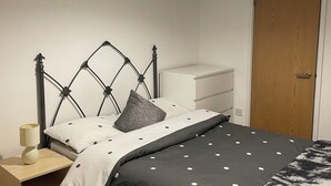 A bedroom with a bed, a bedside table, a nightstand, a wardrobe, and a ceiling light. - City Centre Sunniside Sunderland (Sunderland)