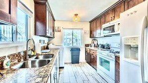 Una cucina moderna con piani in granito, elettrodomestici in acciaio inossidabile e mobili in legno.