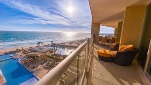 Un balcon avec vue sur la plage, la piscine et l’océan.
