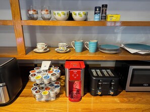 A kitchen area with a coffee maker, toaster, and various kitchenware on the counter. - Experience comfort in our Danvers, MA cute private studio . (Danvers)