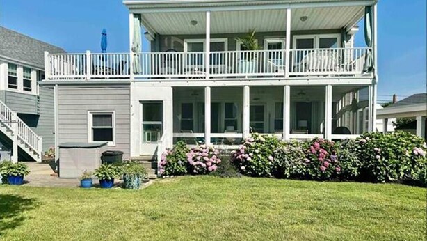 A two-story house with a balcony, a covered porch, and a well-maintained lawn. - Gardens Single-Family Home • Ocean Views • Dog Considered • FRIDAY TO FRIDAY (Ocean City)