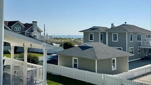 A residential area with houses, a white picket fence, and a clear sky. - Gardens Single-Family Home • Ocean Views • Dog Considered • FRIDAY TO FRIDAY (Ocean City)
