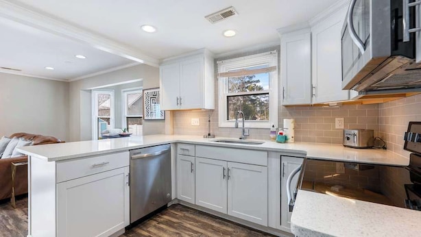 A modern kitchen with white cabinetry, a large island, and a built-in oven. - Spacious Home 3BR Close to Beach Centrally Located (Myrtle Beach)