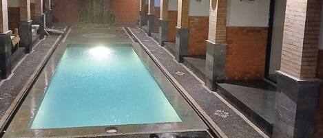 Una piscina al aire libre, tumbonas