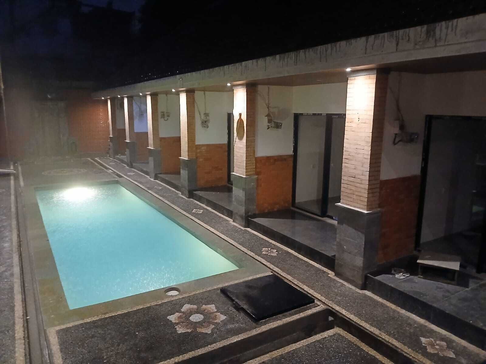 Une piscine dont le bord est recouvert de carreaux et qui présente un motif floral au centre.