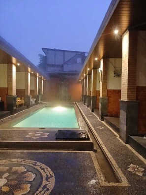 A spa area with a rectangular pool, benches, and a tiled floor. - Ulu Bali Homestay (Jimbaran)