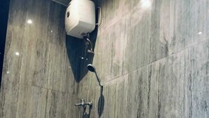 A modern bathroom with a shower, toilet, and a marble wall. - Ulu Bali Homestay (Jimbaran)