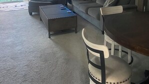 Olohuoneessa on sohva, sohvapöytä ja ruokapöytä tuoleineen. Lisäksi siellä on kattotuuletin, televisio ja golf-aiheinen seinäkoriste.