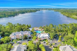Ein Resort mit mehreren Gebäuden, einem Schwimmbad und einem großen Gewässer.