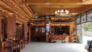 Een traditioneel houten interieur met ingewikkelde houtsnijwerken, een centraal zitgedeelte en een bar.