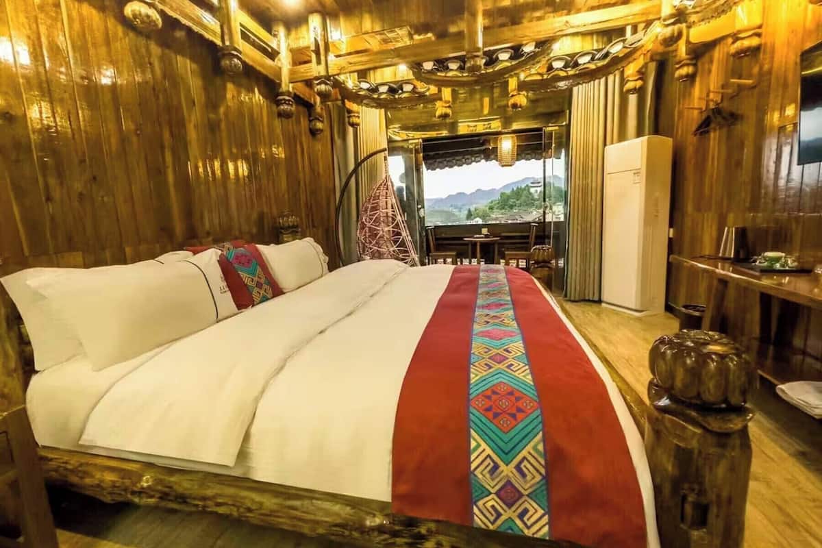 Ein Zimmer mit Holzboden, einem Bett, einem kleinen Tisch und einem Stuhl.