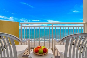 A balcony with a view of the ocean, white chairs, and a basket of fruit. - Bay Watch 1835 (North Myrtle Beach)