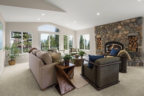 A spacious living room with a stone fireplace, large windows, and a cozy seating area. - Lake View 4BR in Incline Village | Deck & Fireplace (Incline Village)