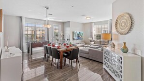 A modern living room with a dining area, a sofa set, and a foosball table. - 4816-303 Family-Friendly 3BR Condo at Vista Cay (Orlando)