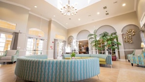 A spacious lobby with a high ceiling, a central seating area, and multiple plants. - 4816-303 Family-Friendly 3BR Condo at Vista Cay (Orlando)